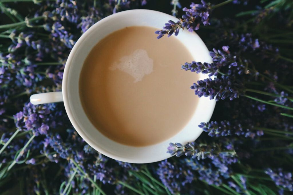 a cup of milk tea or coffee surrounded by lavender flowers