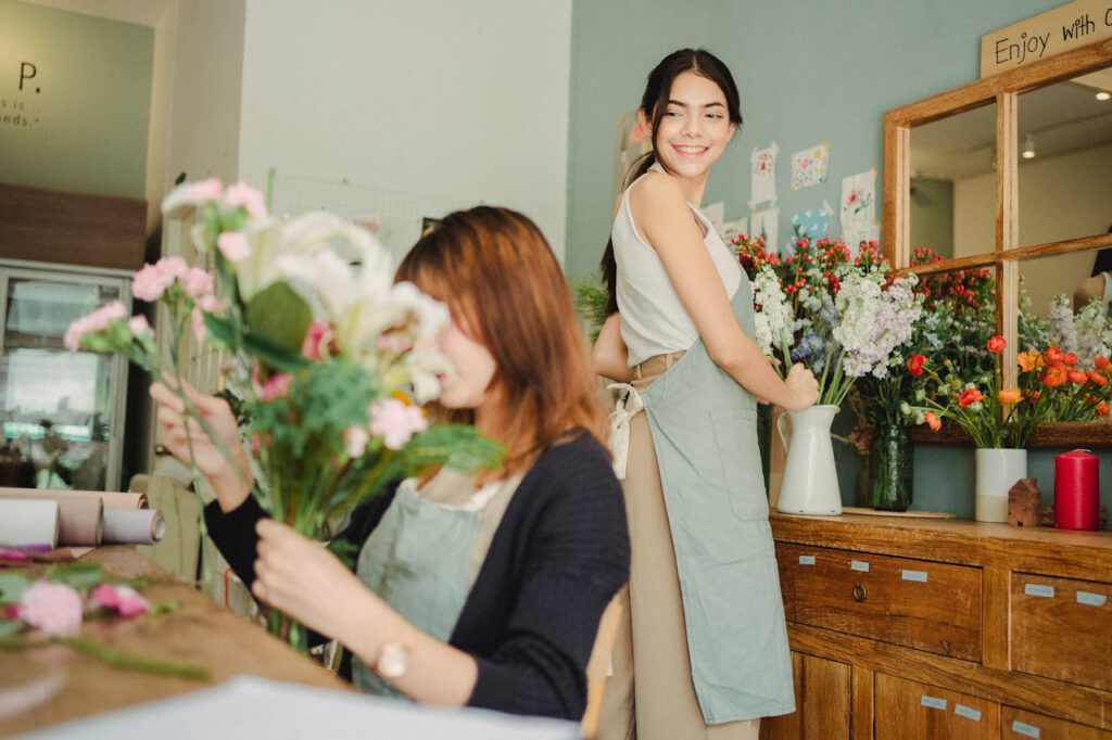 2 women handling flowers for a floral arrangement workshop