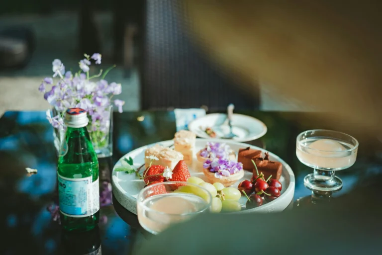 Fruits, drinks, flowers, and floral pastries on a cafe table