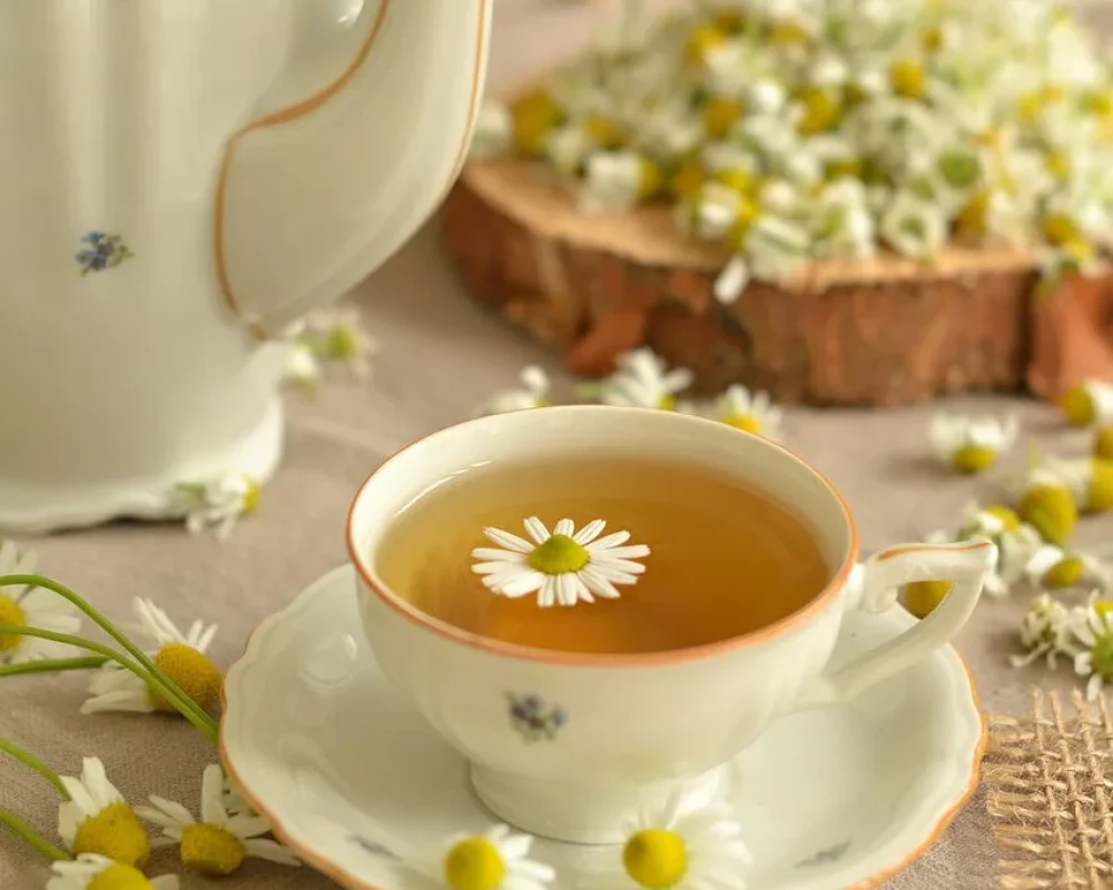 a cup of tea with flowers from the garden in and around it